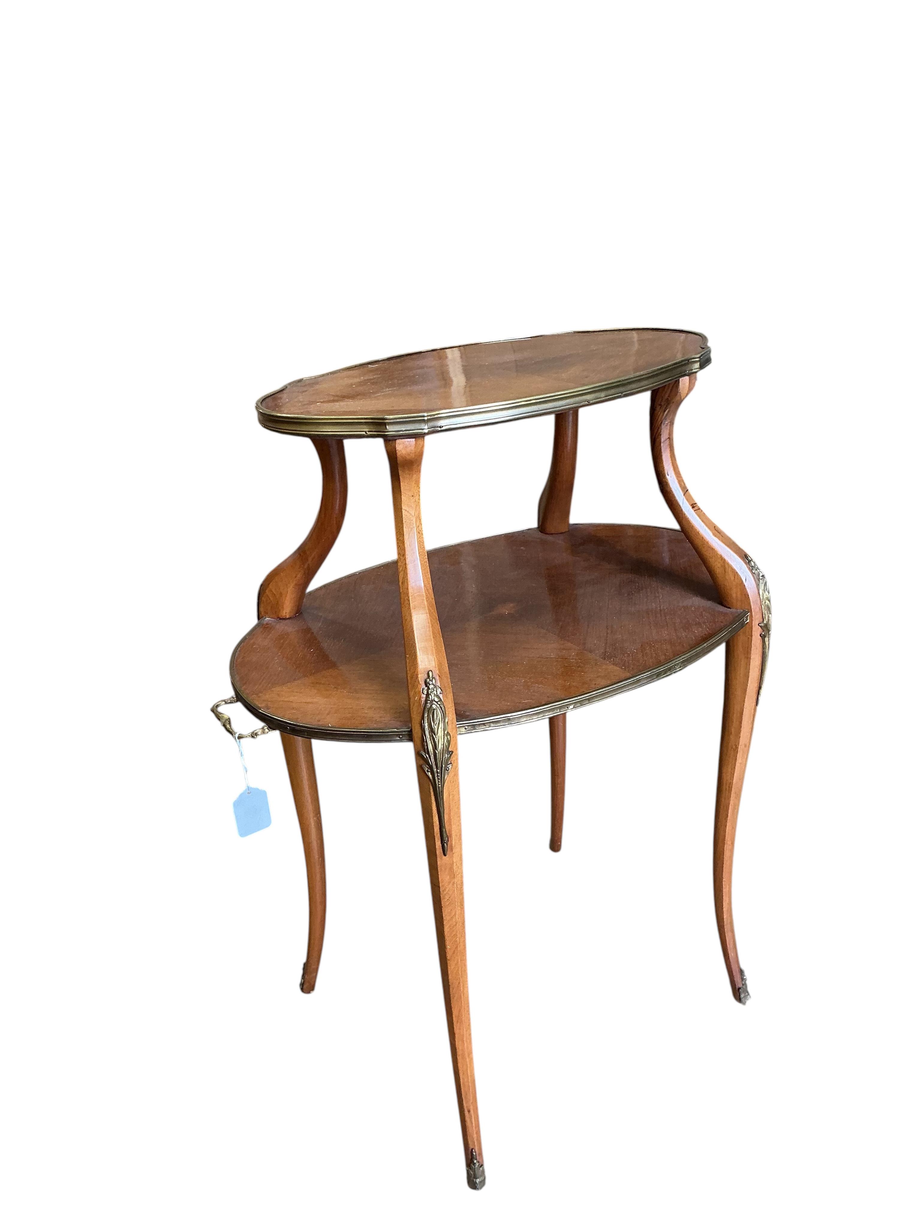 A gilt metal mounted oval mahogany two tier etagere, width 72cm, depth 46cm, height 88cm.